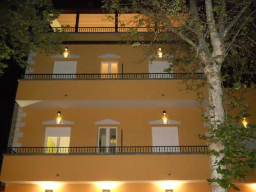 里米尼德拉维斯达酒店的一座黄色的大建筑,晚上有灯