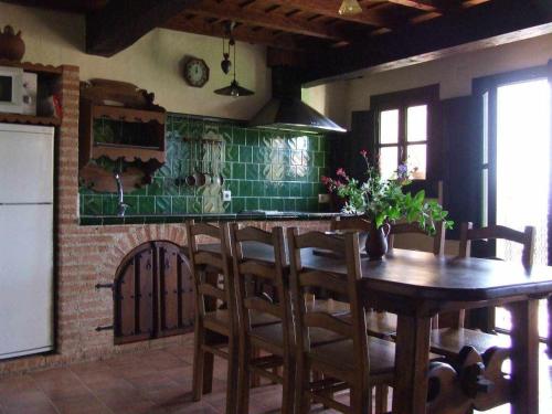 Villanueva del CondeCasas rurales Caño Chico y La Fuente的厨房配有木桌和绿色瓷砖