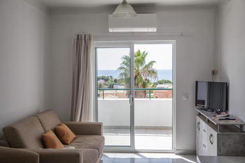 阿尔布费拉Debimar Apartamentos的带沙发的客厅,享有海景
