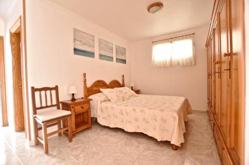 蒂亚斯Colina del Sol Lanzarote Pool with sea view的一间卧室配有一张床和一把椅子