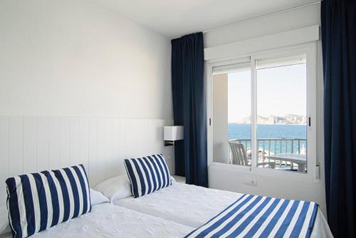 贝尼多姆Apartamentos La Mar的一间卧室设有一张床,享有海景