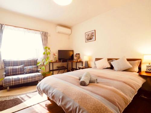 京都遥華-Haruka House的一间卧室配有一张大床和一张沙发