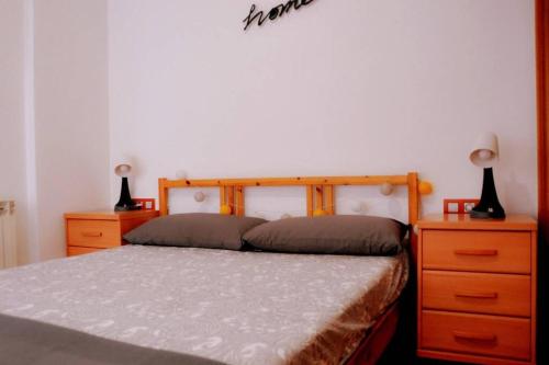 巴达洛纳Casa Luna, junto playa y Barcelona Centro的一间卧室配有一张带2个梳妆台和2盏灯的床。