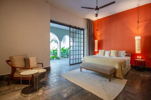 梅里达Antelar Casa Destino的一间卧室配有一张大床和一把椅子