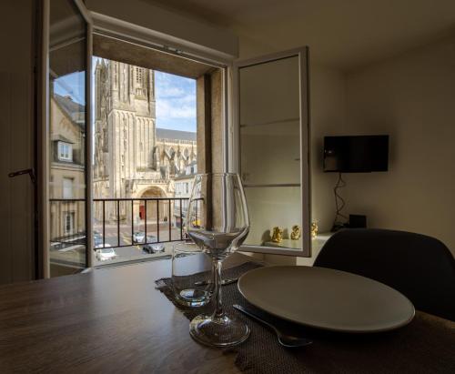 库唐斯Grand F2 refait à neuf, Plein coeur Centre Ville的坐在桌子上的葡萄酒玻璃,窗户