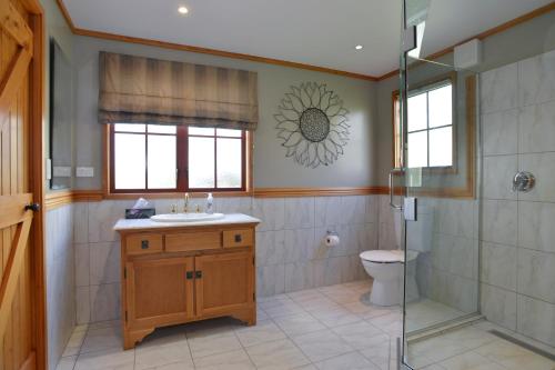 CartertonTerracotta Lodge & Cottages的带淋浴、盥洗盆和卫生间的浴室