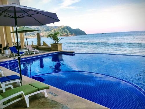 巴拉德纳维达巴格凡特酒店 的一个带椅子和遮阳伞的游泳池以及大海