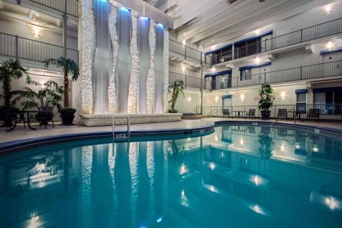 布兰森Quality Inn Branson - Hwy 76 Central的一座游泳池,位于一座带灯光的大建筑内