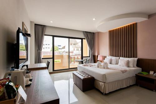 帕他仑博他仑府酒店的一间卧室设有一张大床和一个大窗户