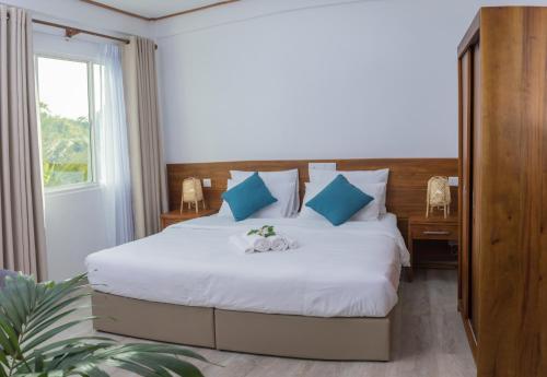 KudarikiluNihaali Maldives的卧室配有带蓝色枕头的大型白色床