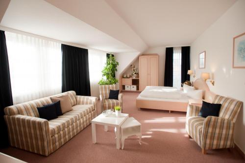 诺德施泰特富力森霍夫酒店的客厅配有沙发和1张床