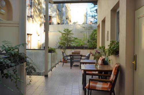 布拉格Self-service Hotel Ostaš Praha的户外庭院设有桌椅和植物