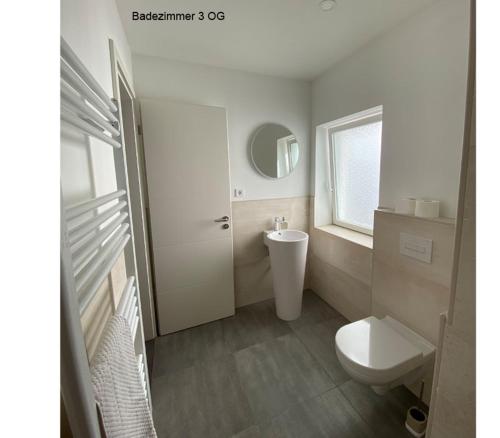 柏林柏林度假屋的白色的浴室设有卫生间和水槽。