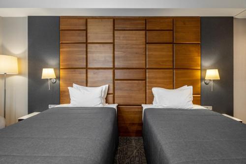 基辅CITYHOTEL的酒店客房设有两张床和两盏灯。