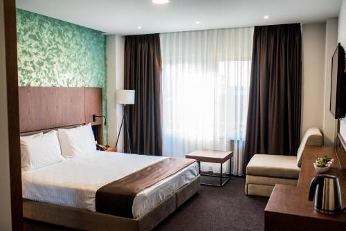 斯特鲁加Hotel Bograd - Apartments & Lounge Station的酒店客房带一张大床和一把椅子