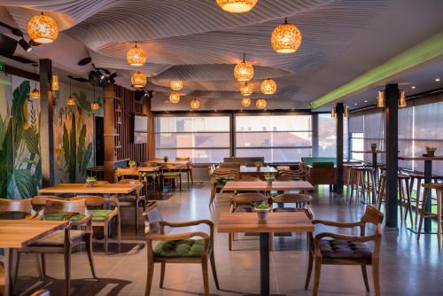 斯特鲁加Hotel Bograd - Apartments & Lounge Station的餐厅设有木桌和椅子及灯