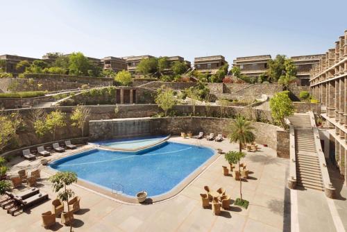 乌代浦华美达乌代布尔度假酒店的一座带椅子的庭院内的游泳池以及一座建筑