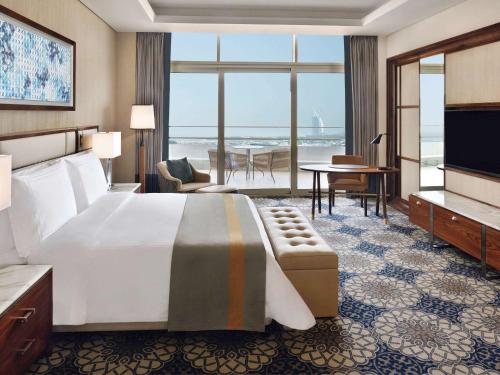 迪拜Grand Plaza Mövenpick的酒店客房设有一张床,享有海景。