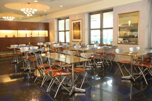 新加坡Classique Hotel的用餐室设有桌椅和窗户。