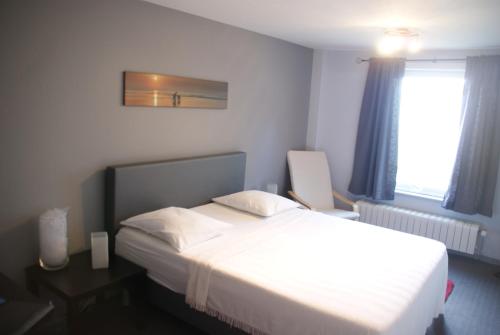 波佩林赫阿洛阿洛度假屋的卧室设有一张白色大床和一扇窗户。