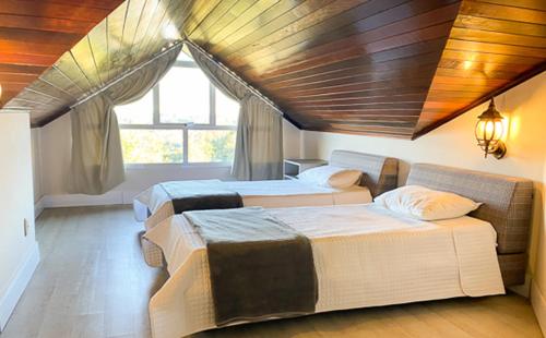 弗洛里斯-达库尼亚Letto Hotel Flores da Cunha的一间卧室设有两张床和窗户。