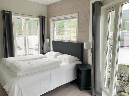 Mefjordvær布里格峡湾酒店的卧室配有白色的床和2扇窗户。