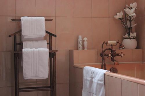 尚托奈Au Coeur du Bocage Vendéen的浴室提供白色毛巾、水槽和浴缸。