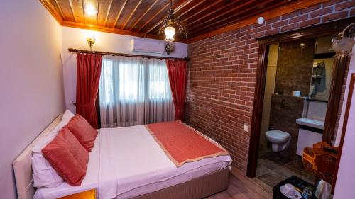 安塔利亚安塔利亚酒店的一间小卧室,配有床和砖墙