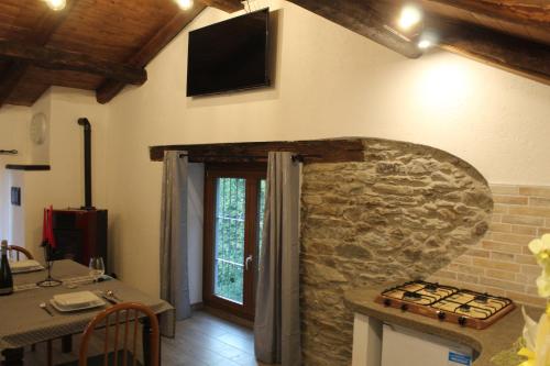 RubianaiCAVA的厨房设有石墙,墙上配有电视