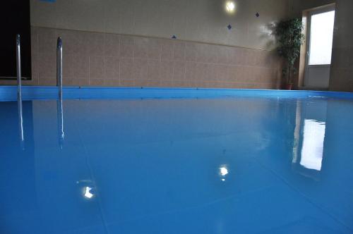 Sloboda ZasluchʼSN Hotel的客房内的大型蓝色游泳池
