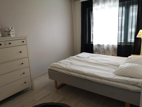 库奥皮奥Apartment Vuorikatu 35的一间卧室配有一张床、一个梳妆台和一扇窗户。