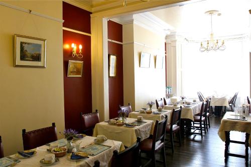 道格拉斯梅尔罗斯旅馆的一间带长桌子和椅子的用餐室以及窗户。