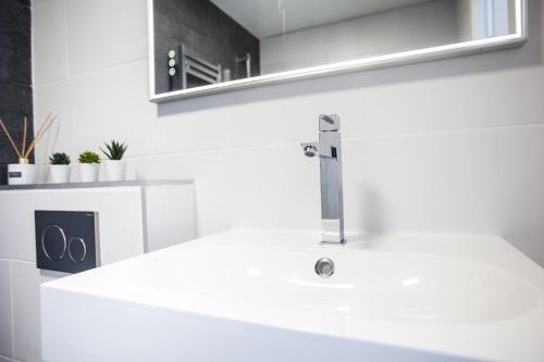 贝利罗曼维利而DISNEYLAND PARIS NEW STUDIO SUITE DESIGN的白色的浴室设有水槽和镜子