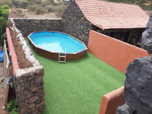 San Jose De Los Llanos卡塞里奥洛杉帕特多斯乡村民宿的一座大游泳池,位于一座建筑旁的院子内