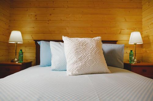 MarkinchCosy Log Cabin - The Dookit - Fife的卧室配有带两盏灯的白色床