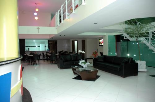 萨尔瓦多Hotel Piramide Pituba - Rua Pernambuco的一间带黑色沙发的客厅和一间用餐室