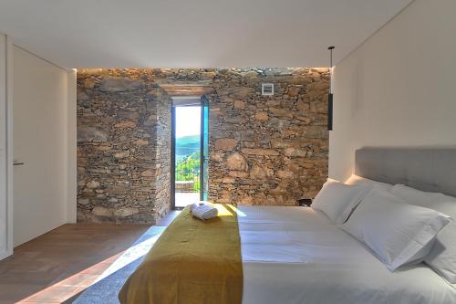 比索达雷加DouroXisto的一间卧室配有一张石墙床
