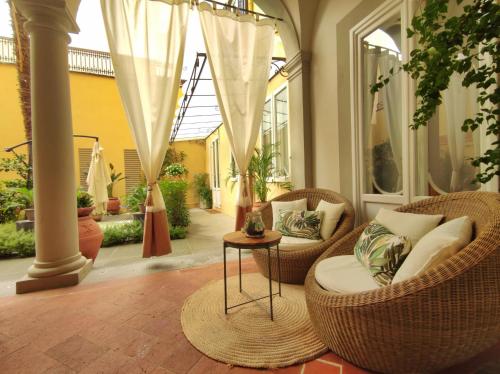 佛罗伦萨Ricasoli Garden Relais的一个带藤椅和桌子的门廊