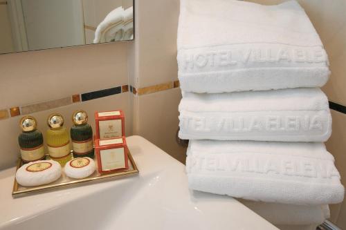 瓦拉泽Genovese Villa Elena Residence的浴室水槽上堆着的毛巾