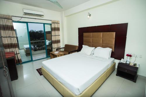 库克斯巴扎密舒克酒店的一间带大床的卧室和一个阳台