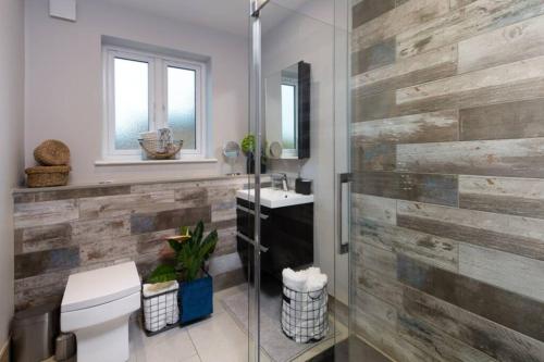 阿伦德尔Roseland Apartment 4的浴室设有木墙、卫生间和水槽。