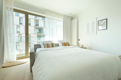 布鲁塞尔The Riverside的白色的卧室设有一张大床和一个窗户