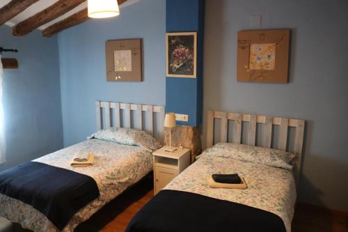 OntiñenaCasa rural tres regiones的卧室设有两张床铺和蓝色的墙壁