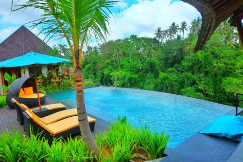 乌布Kadewa Retreat Ubud - Adults Only的一个带椅子和棕榈树的游泳池的度假酒店