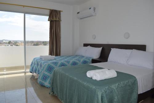 曼塔Mare S&M Casa Hostal的酒店客房设有两张床和大窗户。
