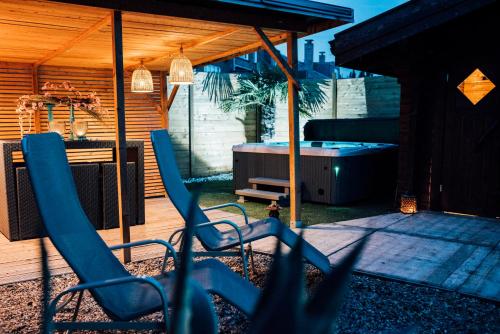 布鲁日B&B A Dream City spa & Massages的一个带蓝色椅子和热水浴缸的庭院