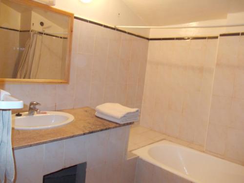 扎古拉普尔勒杜达酒店的一间带水槽、浴缸和镜子的浴室