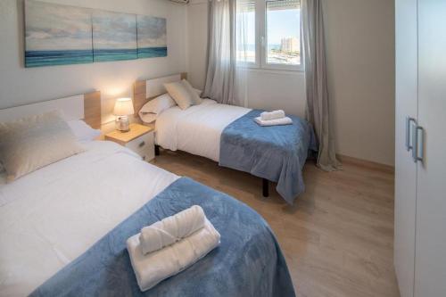 加的斯Apartamento Fenicia con aparcamiento incluido Vistas al mar的酒店客房设有两张床和窗户。