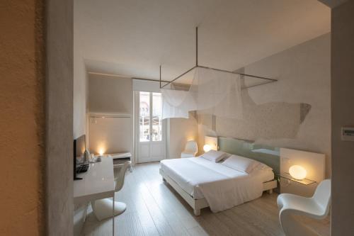 曼托瓦Scaravelli Residenza的一间卧室配有一张床、一张桌子和一把椅子