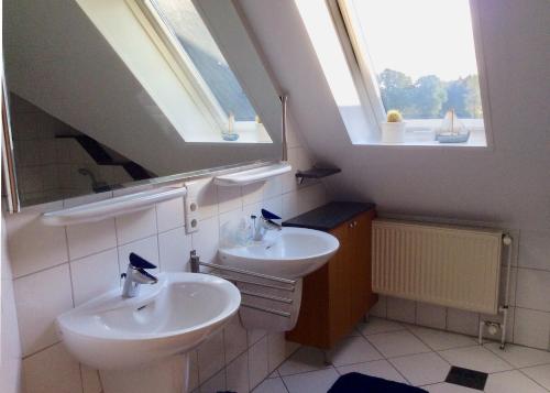LastrupFerienwohnung am Mühlendamm的一间带两个盥洗盆和两个窗户的浴室